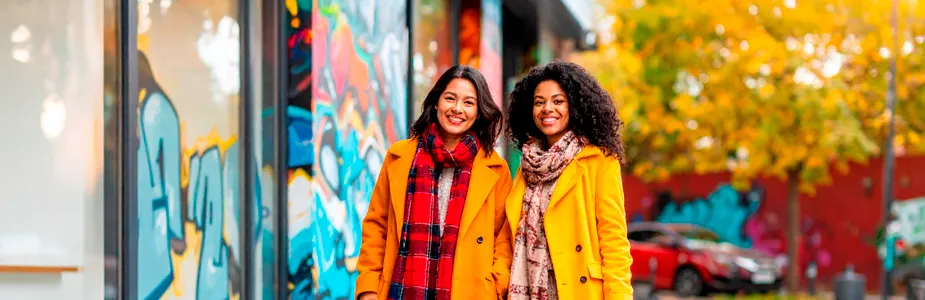 Look de inverno com mulher brasileira estilosa usando casaco moderno em tons quentes e detalhes pretos, destacando tendências da moda.