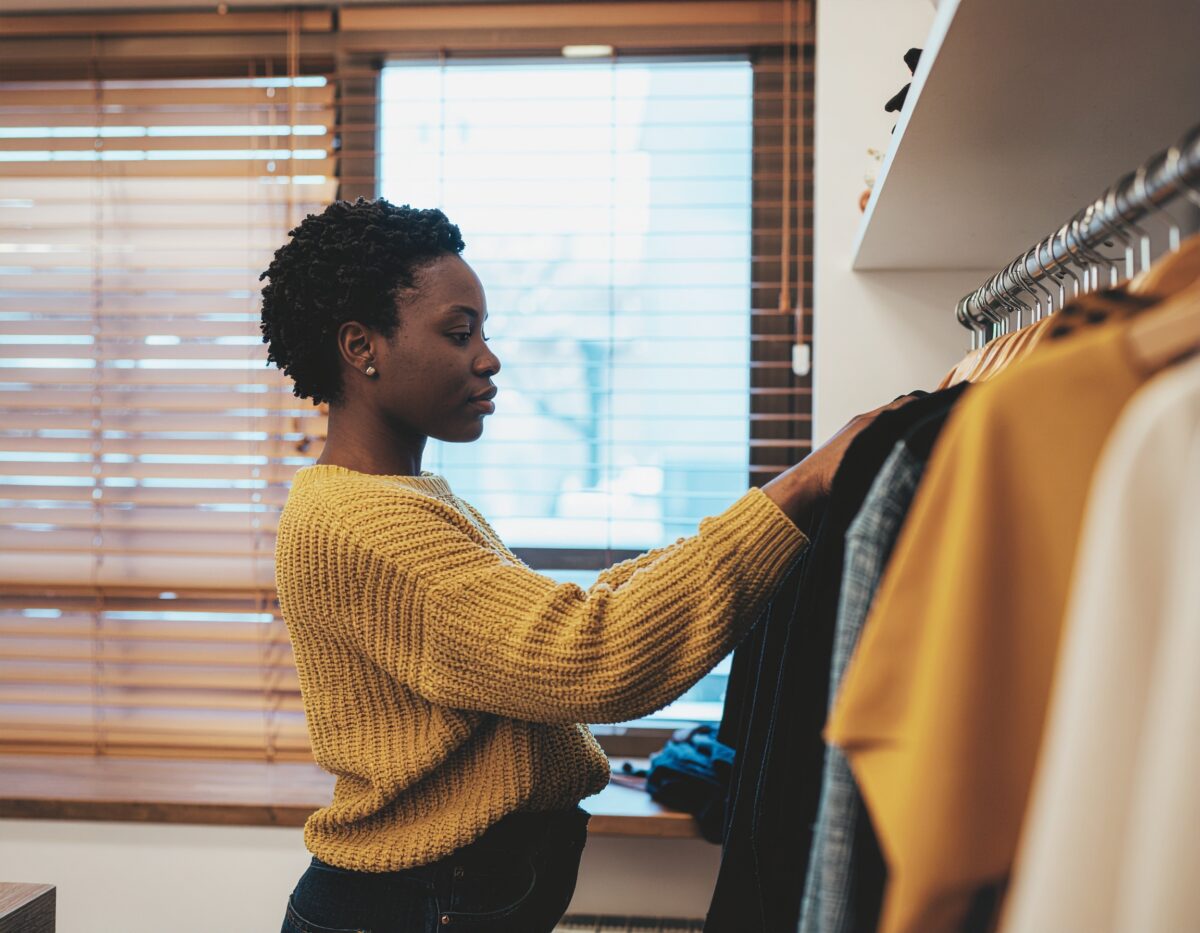 6 Estratégias de Marketing Infalíveis para Lojas em Centros Comerciais - Mulher arrumando roupas de sua loja.